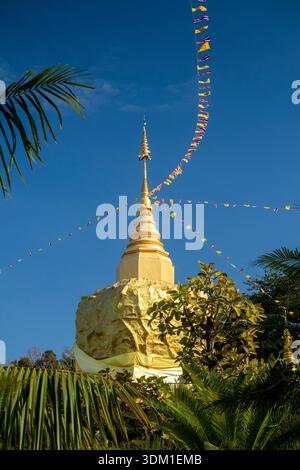 Thailand, Isaan, Sakon Nakhon, Dong Mafai, Phu Pan Mountains, Wat Tham Pha Daen, goldener Rock Chedi mit Gebetsfahnen im Wind Stockfoto