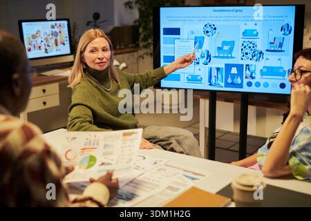 Erwachsene Frau leitet kreatives Meeting mit verschiedenen Kollegen Stockfoto