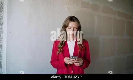 Junge Geschäftsfrau, die ansprechende Videoinhalte für ihre sozialen Medien erstellt. Die Frau nimmt einen Tanz-Trend für ihre Follower auf ihrem Smartphone auf Stockfoto