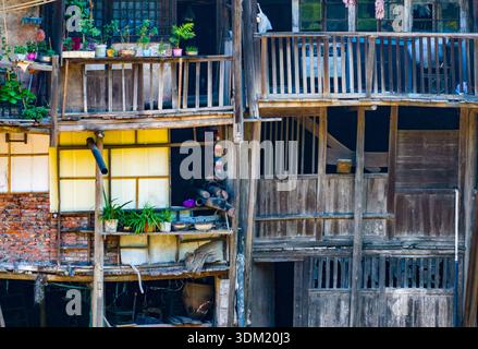 Die antike Stadt Bing’an in Guizhou, China, bietet traditionelle Holzpfahlhäuser entlang eines Flusstals und bewaldete Hügel. Stockfoto