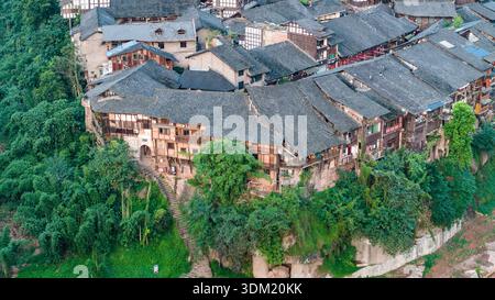 Die antike Stadt Bing’an in Guizhou, China, bietet traditionelle Holzpfahlhäuser entlang eines Flusstals und bewaldete Hügel. Stockfoto