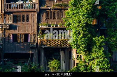 Die antike Stadt Bing’an in Guizhou, China, bietet traditionelle Holzpfahlhäuser entlang eines Flusstals und bewaldete Hügel. Stockfoto