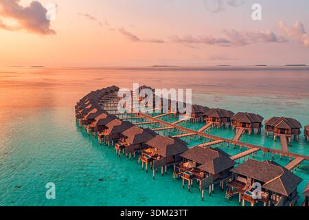 Romantisches Aerial Malediven Luxus Überwasser Resort Sonnenuntergang weit atemberaubendes Paradies exotisches Küstenreiseziel Hintergrund Stockfoto