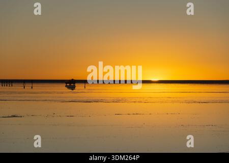 Bei Sonnenuntergang verwandelt sich Salar de Uyuni in einen riesigen Spiegel, in dem Himmel und Erde verschmelzen, Farben in Stille verschmelzen und der Horizont in endloser Ruhe leuchtet. Stockfoto