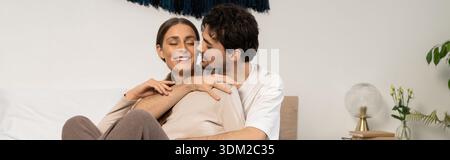 Das Paar teilt Lachen und Wärme in ihrem modernen Zuhause, während es Liebe und Komfort, Banner, liebt Stockfoto