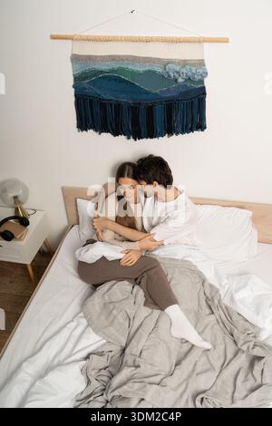 Zwei Liebhaber genießen sich in einem stilvollen Apartment, das in Wärme und Komfort gewickelt ist. Stockfoto