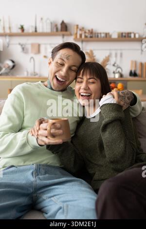 Das Paar lacht und ist warm, während es sich entspannt und eine glückselige Atmosphäre schafft. Stockfoto