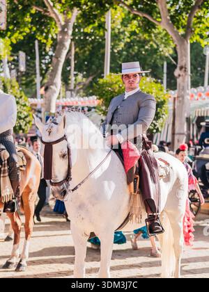 Spanischer Reiter in traditioneller Kleidung zu Pferd bei einer Outdoor-Kulturveranstaltung. Stockfoto