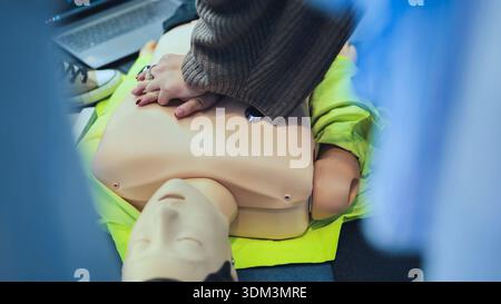 Hände, die kardiopulmonale Reanimation an einer Trainingskuppe zur ersten Hilfe durchführen Stockfoto