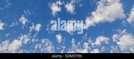 Sonniger blauer Himmel mit flauschigen weißen Wolken natürlicher Skyscape Hintergrund heller Sommertag stimmungsvolle Landschaft im Freien Stockfoto