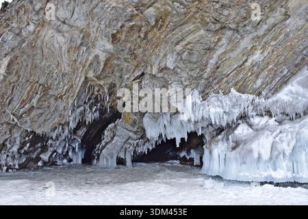 Gefrorene Klippen und Eishöhlen auf Olkhon Island am Baikal-See im Winter, dicke Eiszapfen bilden bei extremer Kälte die dramatische Felsenküste. Stockfoto