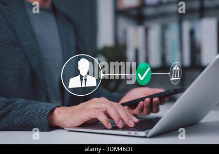 Online-Banking-Konzept mit sicherer Identitätsprüfung und digitaler Transaktionsgenehmigung, wobei ein Geschäftsmann mit Laptop und Smartphone arbeitet Stockfoto
