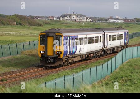 Dieseltriebwagen der Northern Rail Class 156, die an den Küstengolfverbindungen in Großbritannien vorbeifahren und regionale Personenbahnen in landschaftlich reizvoller Umgebung präsentieren. Stockfoto