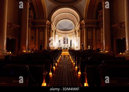 Menschen in der katholischen Kirche, beleuchtet von gefälschten flammenlosen LED-dekorativen Kerzen. Basilika St. Katharina von Alexandria in Sankt Petersburg, Russland, N Stockfoto