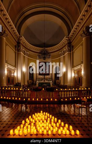 Katholische Kirche beleuchtet durch gefälschte flammenlose LED-dekorative Kerzen. Basilika St. Katharina von Alexandria in Sankt Petersburg, Russland, 5. November 202 Stockfoto