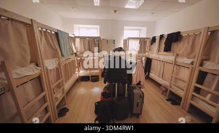 Hostel Schlafsaal mit mehreren Etagenbetten und Gepäck, bietet preisgünstige Unterkunft für Reisen Stockfoto