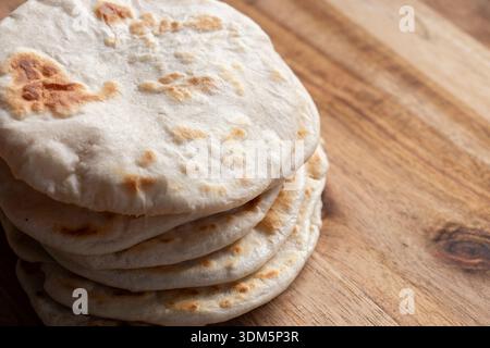 Hausgemachtes Fladenbrot auf einem hölzernen Schneidebrett. Einfaches Rezeptkonzept für hausgemachtes Brot. Stockfoto