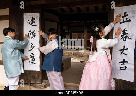 Südkorea. Februar 2026. Kinder und ein Kalligraf kleben am 4. Februar 2026 Ipchuncheop, traditionelle Kalligrafieblätter, die den Beginn des Frühlings begrüßen, an den Türen des Ochondack im National Folk Museum of Korea in Seoul, Südkorea. Ipchun ist der erste von 24 Sonnenterminen, der den Beginn der Frühlingssaison signalisiert. (Foto: Chris Jung/NurPhoto)0 Credit: NurPhoto SRL/Alamy Live News Stockfoto