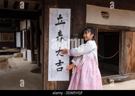 Südkorea. Februar 2026. Kinder und ein Kalligraf kleben am 4. Februar 2026 Ipchuncheop, traditionelle Kalligrafieblätter, die den Beginn des Frühlings begrüßen, an den Türen des Ochondack im National Folk Museum of Korea in Seoul, Südkorea. Ipchun ist der erste von 24 Sonnenterminen, der den Beginn der Frühlingssaison signalisiert. (Foto: Chris Jung/NurPhoto) Credit: NurPhoto SRL/Alamy Live News Stockfoto