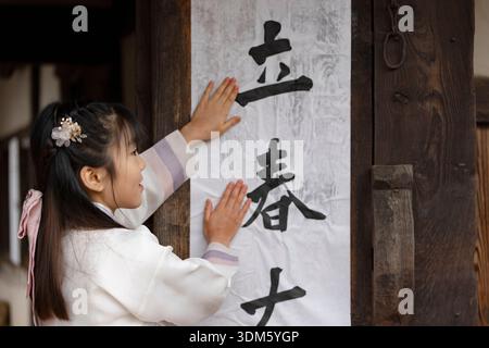 Südkorea. Februar 2026. Kinder und ein Kalligraf kleben am 4. Februar 2026 Ipchuncheop, traditionelle Kalligrafieblätter, die den Beginn des Frühlings begrüßen, an den Türen des Ochondack im National Folk Museum of Korea in Seoul, Südkorea. Ipchun ist der erste von 24 Sonnenterminen, der den Beginn der Frühlingssaison signalisiert. (Foto: Chris Jung/NurPhoto)0 Credit: NurPhoto SRL/Alamy Live News Stockfoto