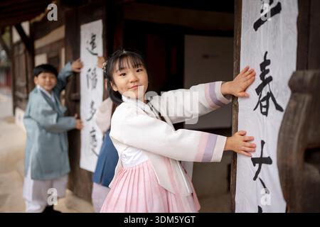Südkorea. Februar 2026. Kinder und ein Kalligraf kleben am 4. Februar 2026 Ipchuncheop, traditionelle Kalligrafieblätter, die den Beginn des Frühlings begrüßen, an den Türen des Ochondack im National Folk Museum of Korea in Seoul, Südkorea. Ipchun ist der erste von 24 Sonnenterminen, der den Beginn der Frühlingssaison signalisiert. (Foto: Chris Jung/NurPhoto)0 Credit: NurPhoto SRL/Alamy Live News Stockfoto