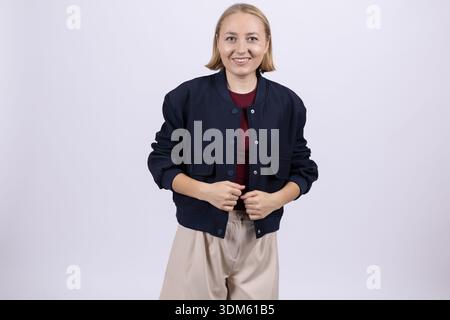 Lächelnde Geschäftsfrau im schwarzen Blazer posiert im Studio Stockfoto