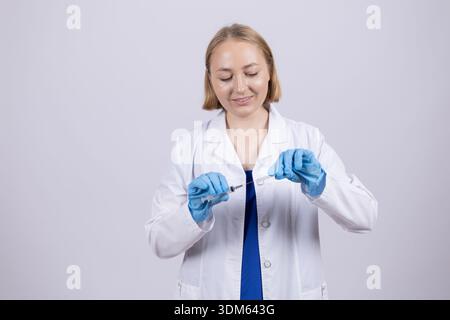 Ärztin im weißen Labormantel mit blauen Handschuhen Stockfoto