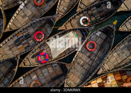 Dhaka, Bangladesch - 31. August 2024: Aus der Vogelperspektive auf traditionelle Holzboote, die dicht zusammengepfercht sind und deren rustikale Texturen von der Sonne hervorgehoben werden Stockfoto