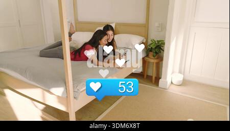 Liegende Frauen in roten und dunklen Spitzen scrollen Telefone im Schlafzimmer mit Herzsymbolen 53 Benachrichtigung Stockfoto