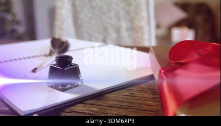 Sitzende Glastinte Flasche auf Holztisch neben Fenster, mit Spiralnotizbuch, Feder, Geschenk, Flare Stockfoto