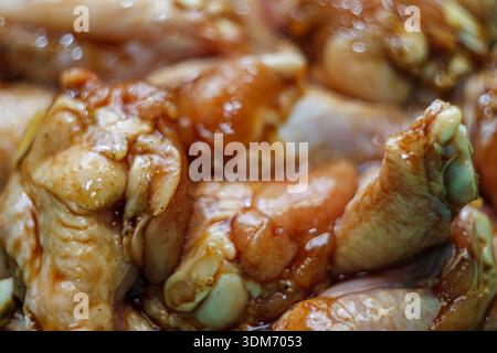 Rohe Hähnchenflügel marinieren in Sojasauce und Gewürzen aus nächster Nähe. Vorbereitung zum Grillen oder Rösten. Stockfoto
