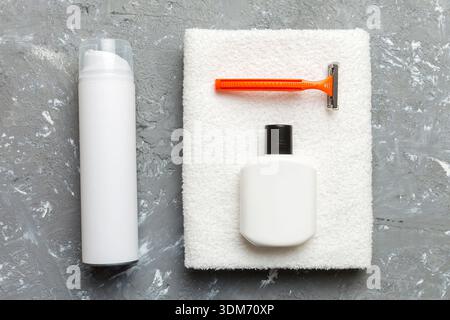 Rasierer-Set. Schermaschine, Handtuch, Lotion und Rasierschaum auf farbigem Hintergrund. Herren Bad Accessoires Draufsicht. Stockfoto