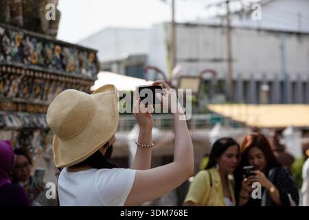 BANGKOK, THAILAND, 15. JAN 2026: Weibliche Touristen fotografieren mit Smartphone und erkunden den Thai-Tempel, Nahaufnahme, Wat Arun Stockfoto