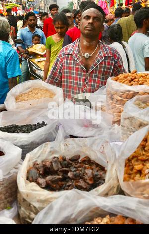 Indischer Straßenverkäufer, der Trockenfrüchte und Nüsse auf dem lebhaften Puducherry Market in Indien verkauft Stockfoto