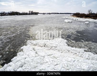 03. Februar 2026, Schleswig-Holstein, Geesthacht: Eisschollen driften flussabwärts auf der Elbe unterhalb der Elbbrücke hinter dem Geesthacht-Stauwerk bei der Stadt Rönne (Landkreis Harburg in Niedersachsen). Nach Tagen des Frosts mit Temperaturen um 10 Grad unter Null stapeln sich Eisberge an den Ufern, einige von ihnen mehrere Meter hoch. Die Eisberge entstanden, nachdem Eisbrecher eingesetzt wurden, um den Fluss oberhalb der Brücke zu räumen, sodass das Wasser abfließen konnte. Das aufgebrochene Eis landet auf dem Ufer unterhalb der Brücke aufgrund der Strömung und stapelt sich in Berge. Viele Besucher besuchen das ICE lan Stockfoto