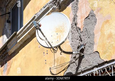 Satellitenschüssel an der Wand des alten Steinhauses Stockfoto