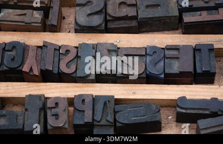 Alte, rostige englische Buchdruck- und Zahlendruckblöcke auf dem Flohmarkt in Paris, Frankreich. Vintage-Hintergrund. Stockfoto