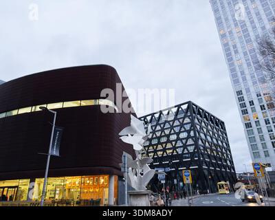 Manchester, Großbritannien - 21. Januar 2026: Modernes Stadtmuseum mit einem runden roten Gebäude, einem Glasbüro und einer weißen Skulptur Stockfoto