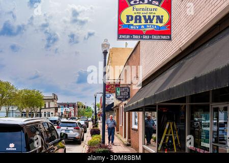 Eine Straßenszene im Zentrum von Emporia zeigt lokale Unternehmen, Ladenschilder, geparkte Fahrzeuge und Fußgänger entlang eines Geschäftsblocks. Stockfoto