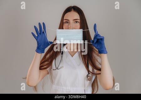 Mit Gesichtsmaske. Die Ärztin ist im Studio. Stockfoto
