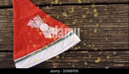 Roter Filzhut mit weißem Rand, Schnürkreuz und Knopf auf verwitterten Dielen, gelbes Bokeh Stockfoto