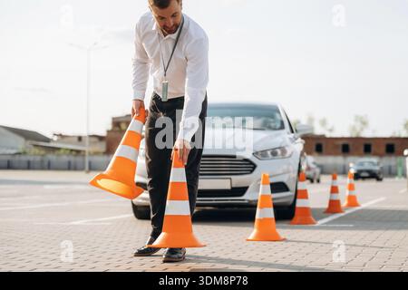 Fahrschularbeiter ist draußen in der Nähe des Autos. Stockfoto