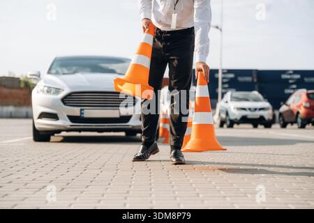 Fahrschularbeiter ist draußen in der Nähe des Autos. Stockfoto