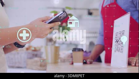 Das Smartphone in der Hand halten, den QR-Code-Ständer des Kunden an der Kaffeekasse berühren, der Barista trägt eine rote Schürze Stockfoto