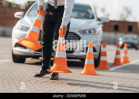 Fahrschularbeiter ist draußen in der Nähe des Autos. Stockfoto