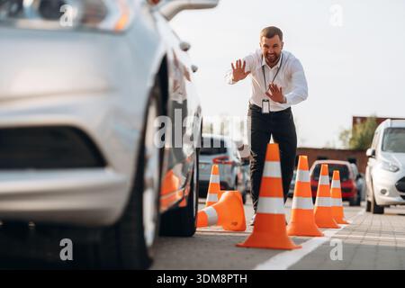Der Fahrschullehrer kontrolliert das Parken eines Autos. Stockfoto