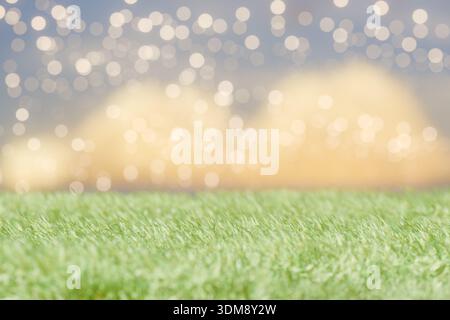 Grünes Gras mit verschwommenen Lichtern im Hintergrund für eine festliche Atmosphäre. 3D-Rendering Stockfoto