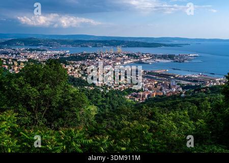 Hochwinkelblick auf die Stadt und den Hafen von Triest mit dem Golf von Triest und dem Karstplateau in der Ferne. Stockfoto