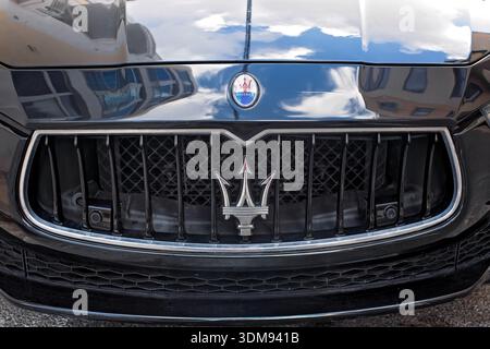 Sliema, Malta - 5. November 2025: Nahaufnahme einer glänzenden Motorhaube mit Himmelsreflexen und dem silbernen Dreizack-Logo eines schwarzen Luxuswagens Maserati auf einer Straße Stockfoto