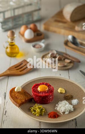 Rindertartar mit zubereiteten Zutaten auf einem Teller für ein Gourmet-Essen Stockfoto